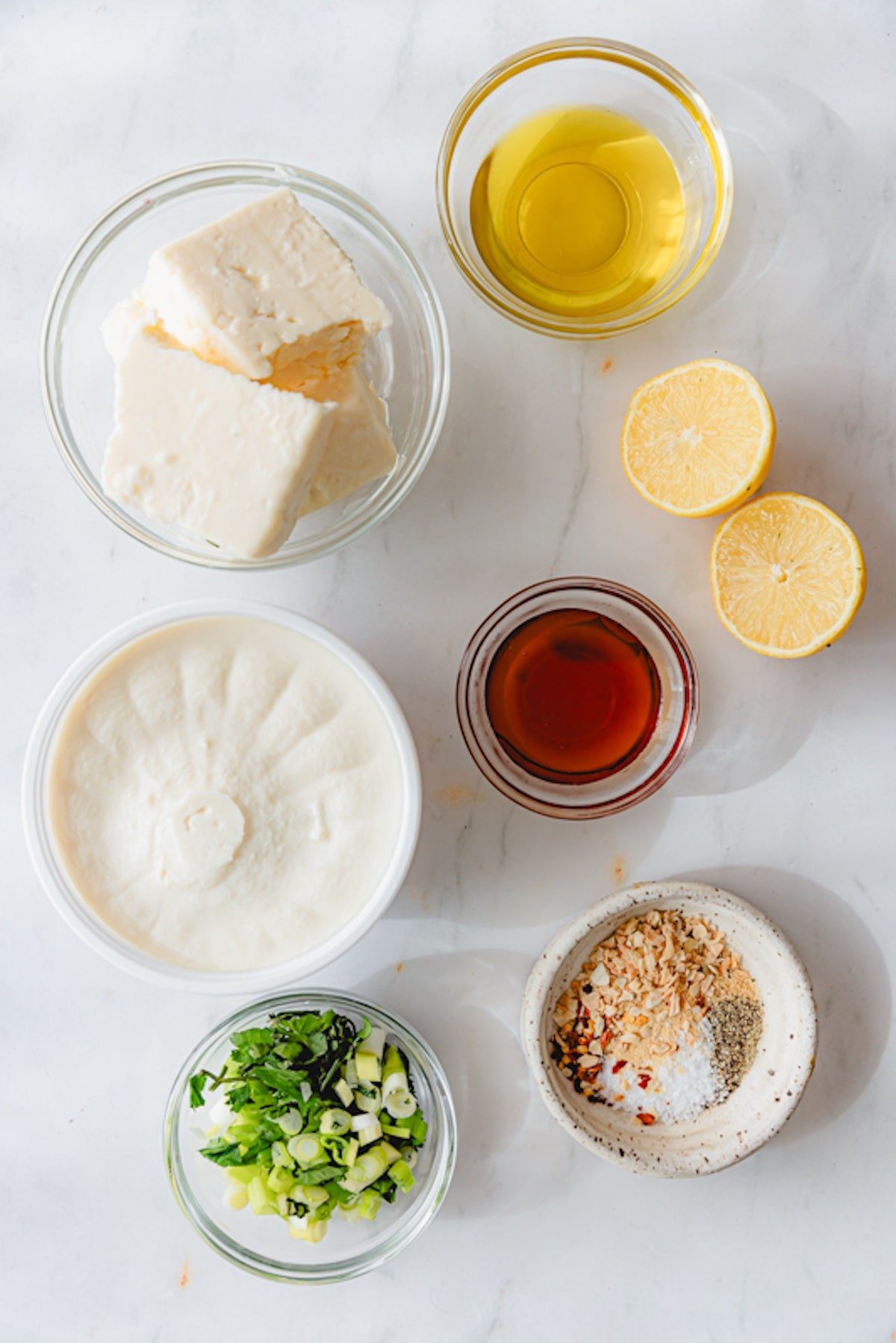 Ingredients for whipped feta and ricotta dip in glass bowls. 