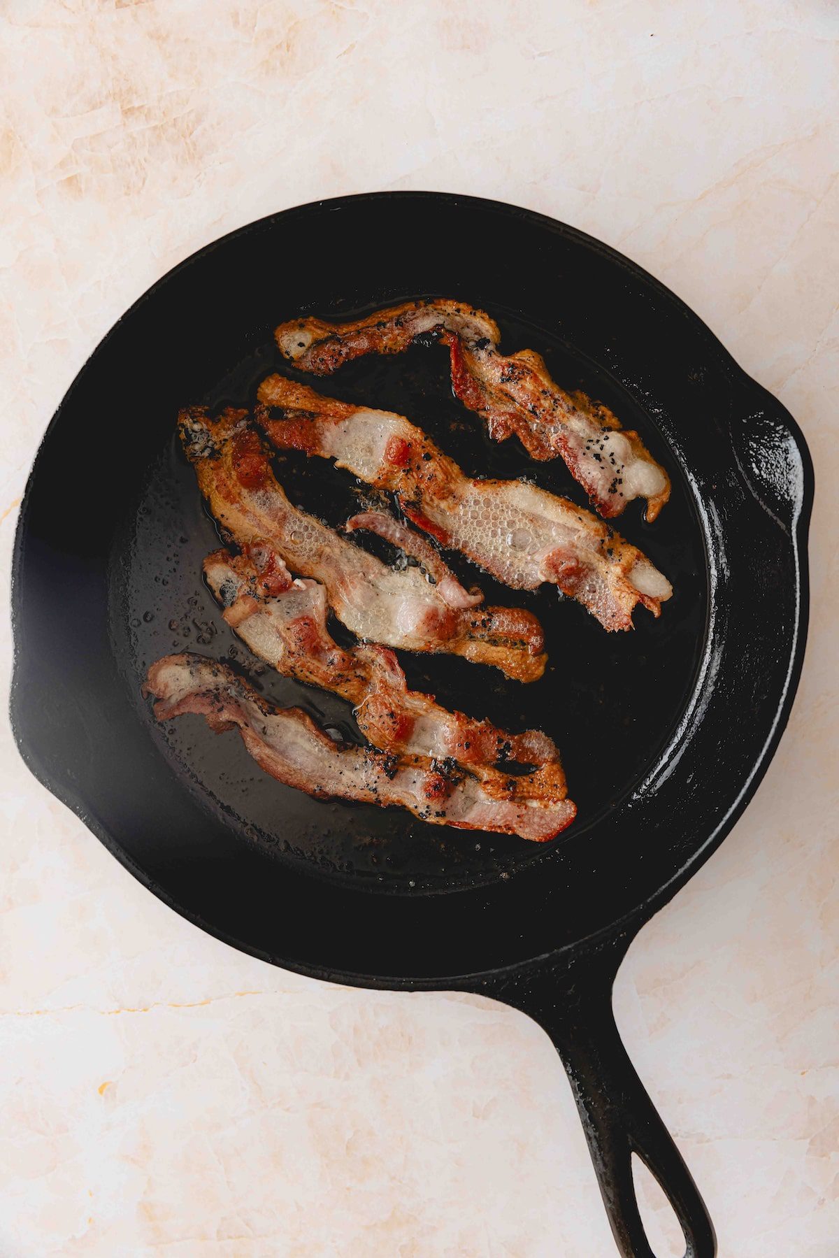 Cooking bacon in a cast iron skillet.