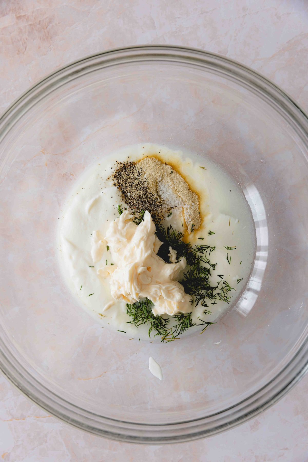 Mixing the dill pickle dressing in a glass bowl.