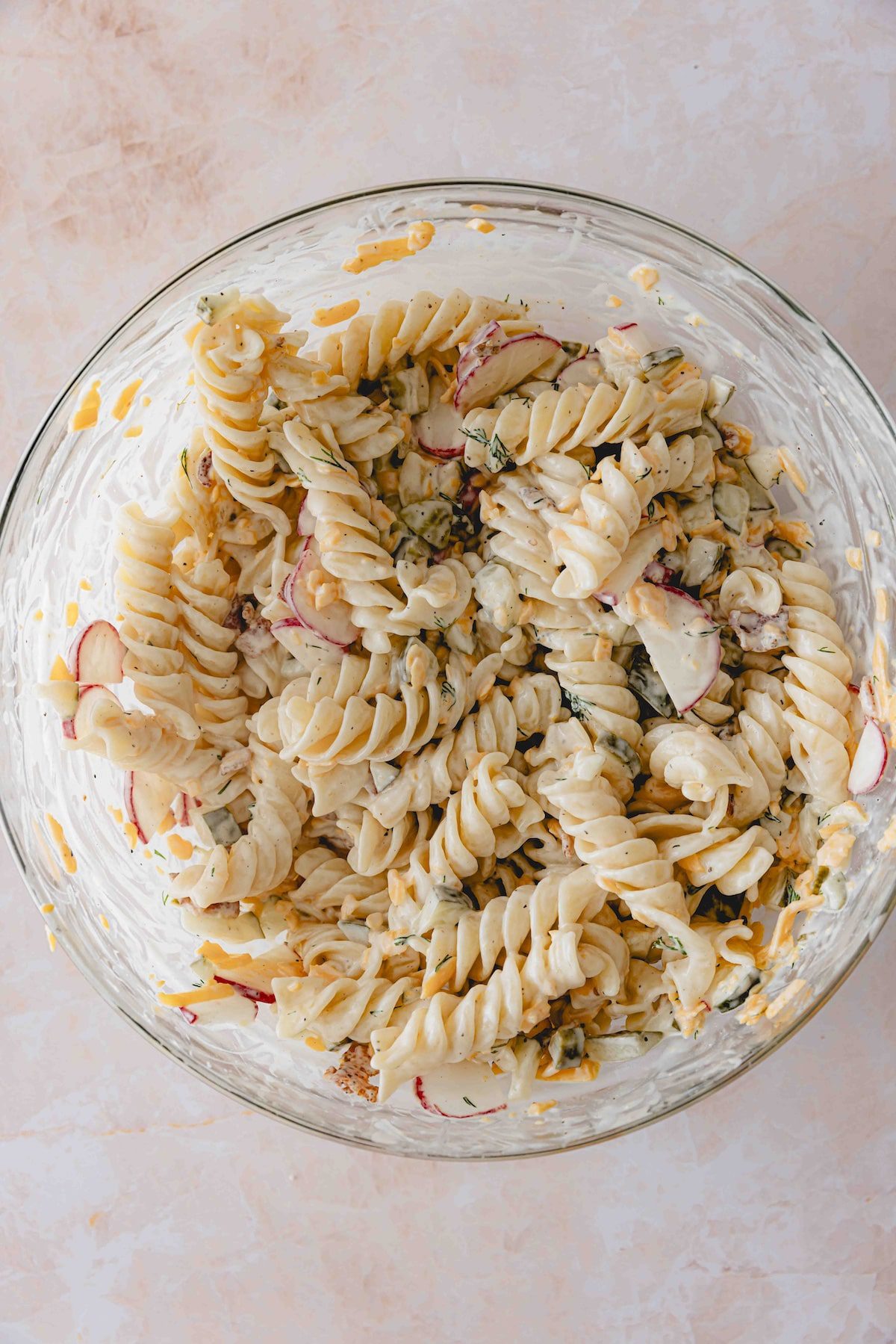 Dill pickle pasta salad in a glass mixing bowl.