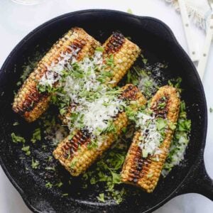 Final plated ears of corn in a skillet.