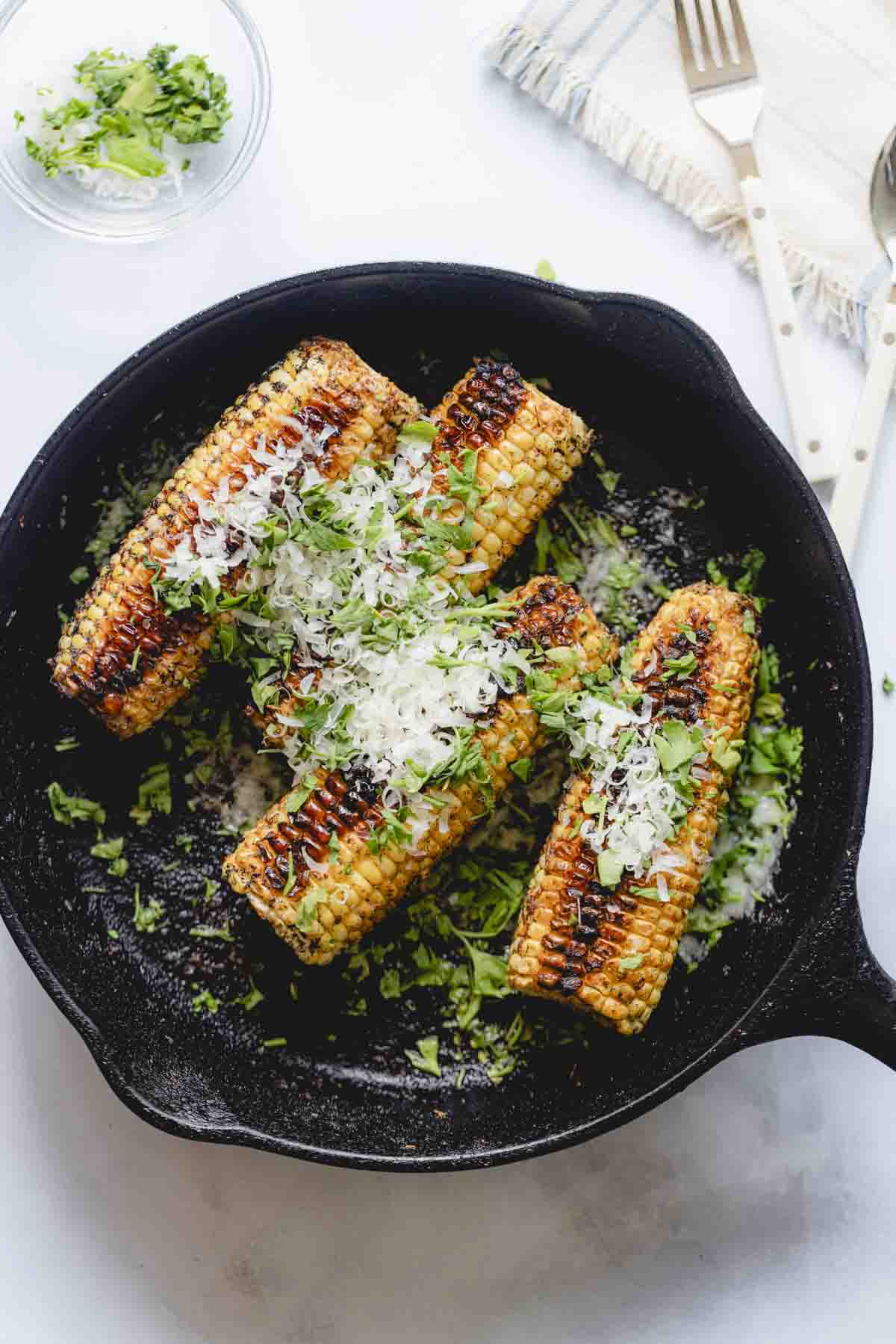 Final plated ears of corn in a skillet. 