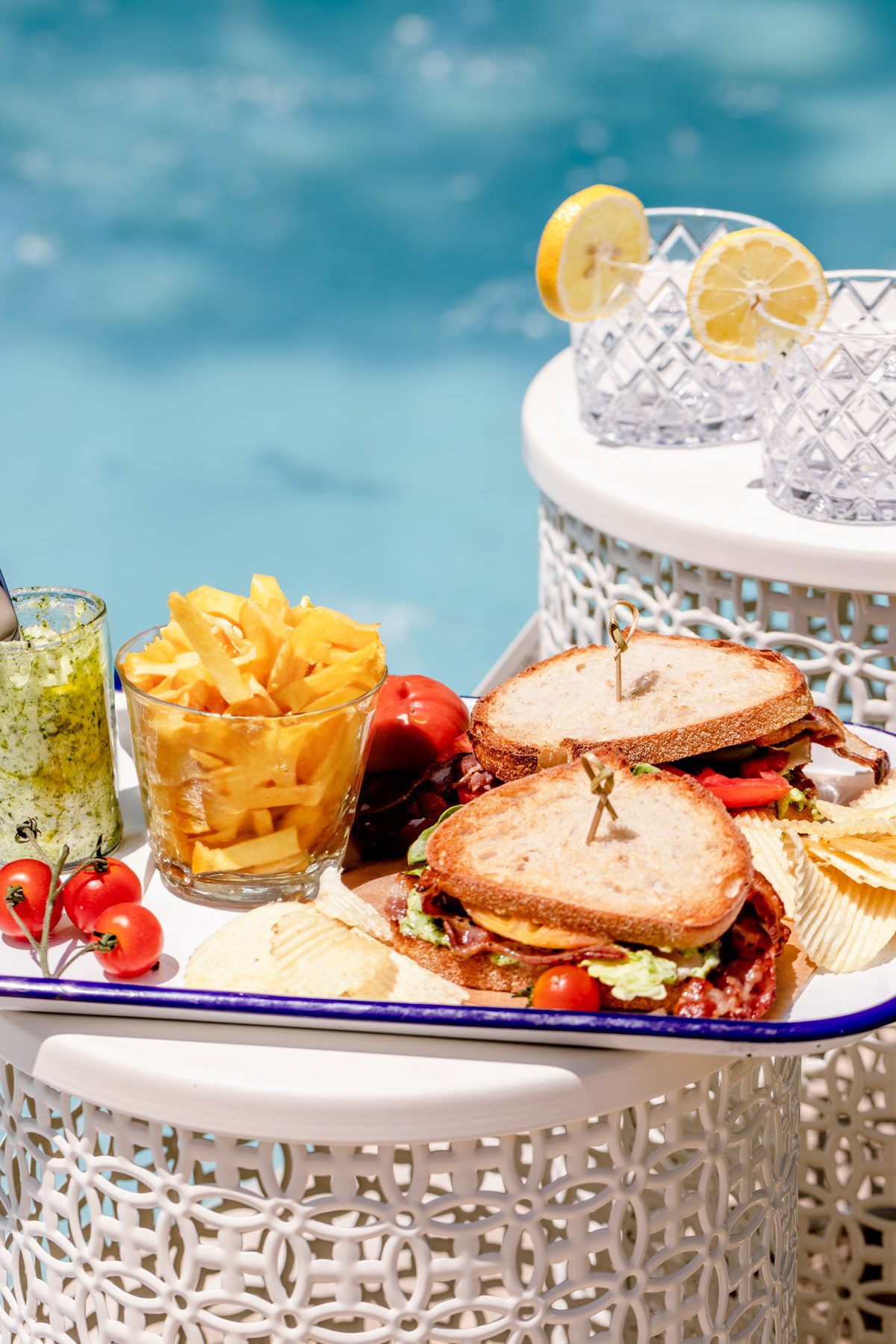 Poolside sandwiches and chips served on a platter.