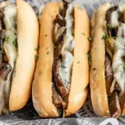 A closeup shot of three vegetarian french dip sandwiches.