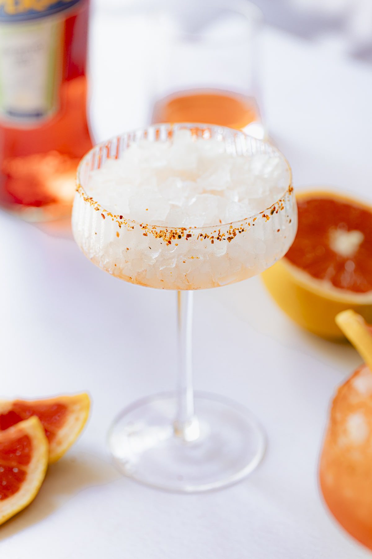 A tajin-rimmed cocktail glass full of ice.