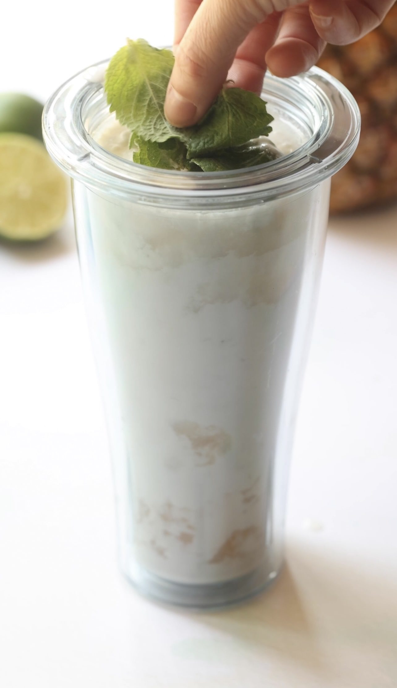 All ingredients for coconut mojitos in a blender cup. 