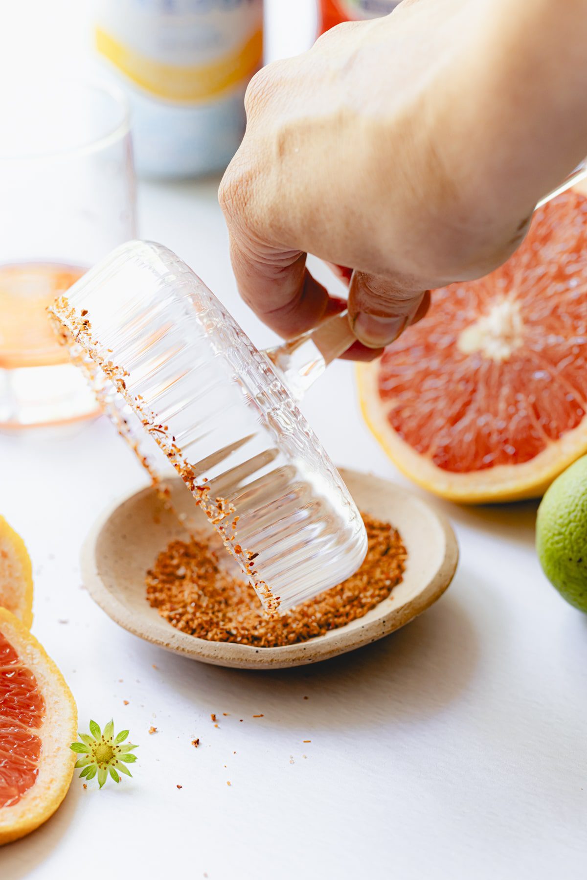 Dipping the cocktail rim into the Tajin mixture.