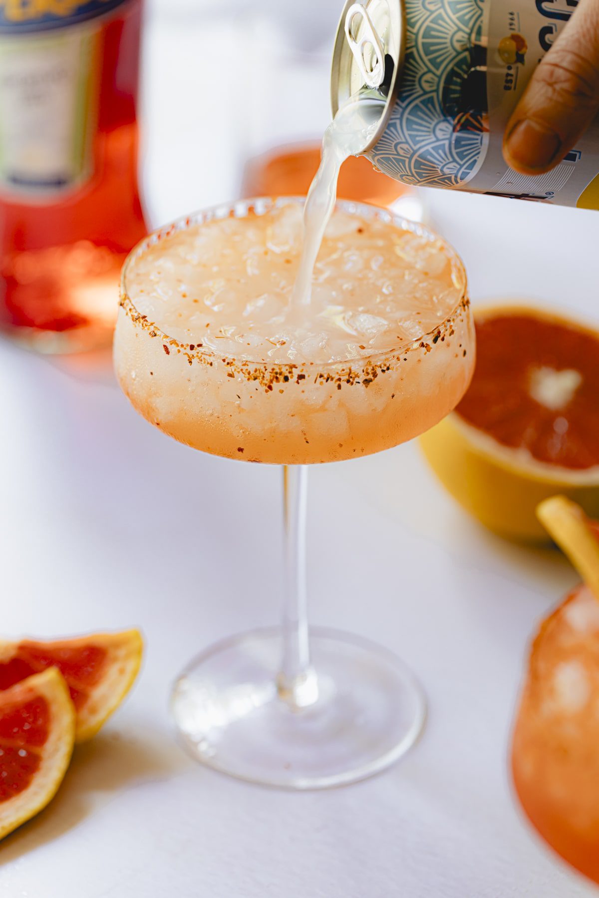 Pouring the Fresca into the glass of Aperol Paloma.