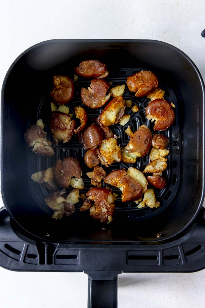 Seasoned red potatoes in an air fryer basket. 