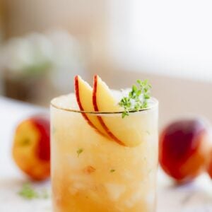 Peach Bourbon Smash with a thyme sprig garnish.