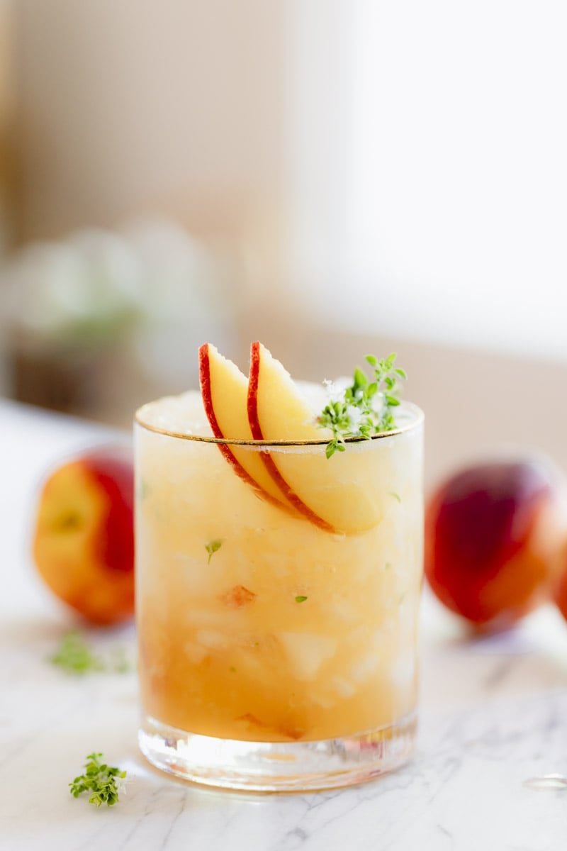 Peach Bourbon Smash with a thyme sprig garnish.