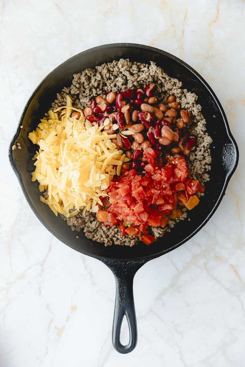 Beans, cheese, and Rotel added to ground beef in skillet. 