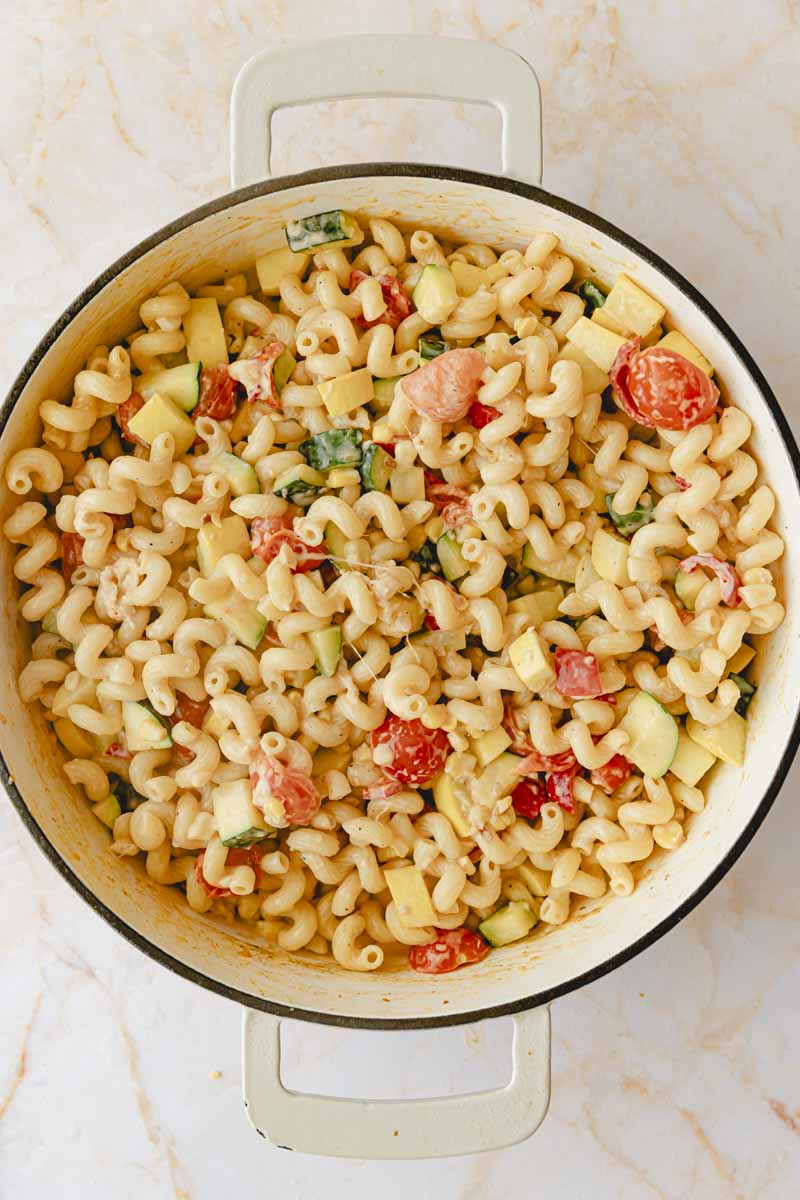 Pasta added to the creamy vegetables in skillet.