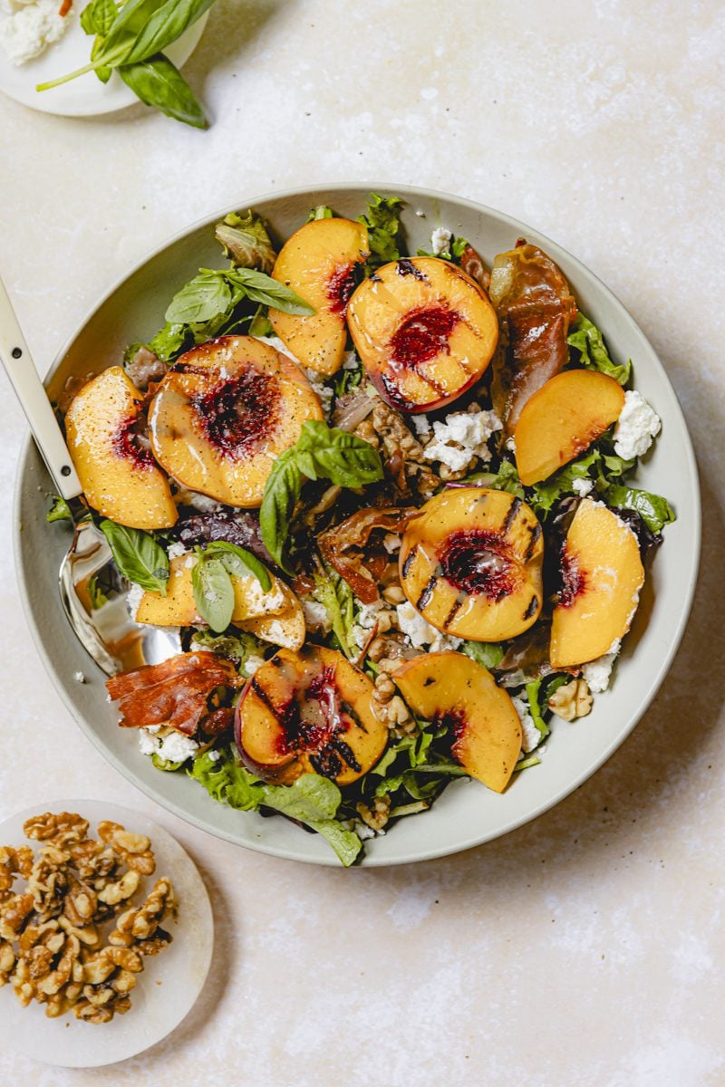 Final plated grilled peach salad with goat cheese.