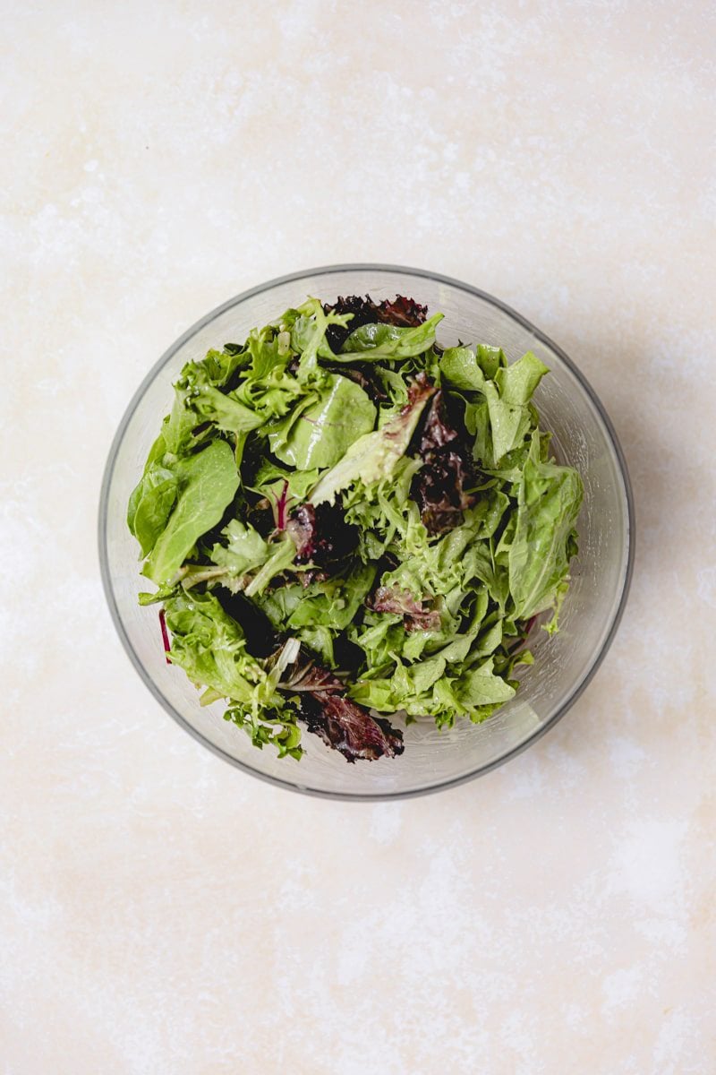 Salad greens tossed in dressing. 
