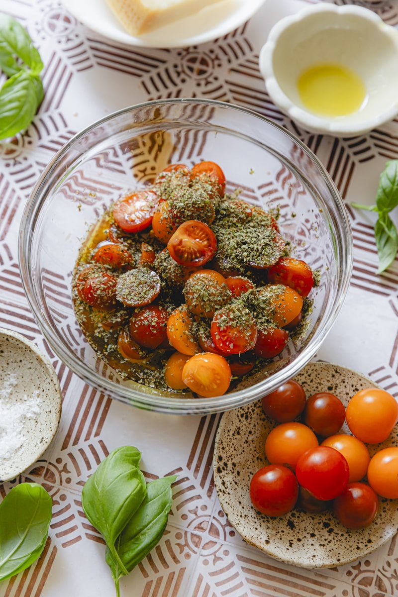 All ingredients for the tomato salad in a glass bowl. 