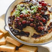 Baked brie with grapes and fig jam in a mini skillet.
