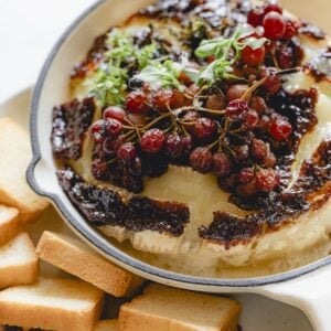 Baked brie with grapes and fig jam in a mini skillet.