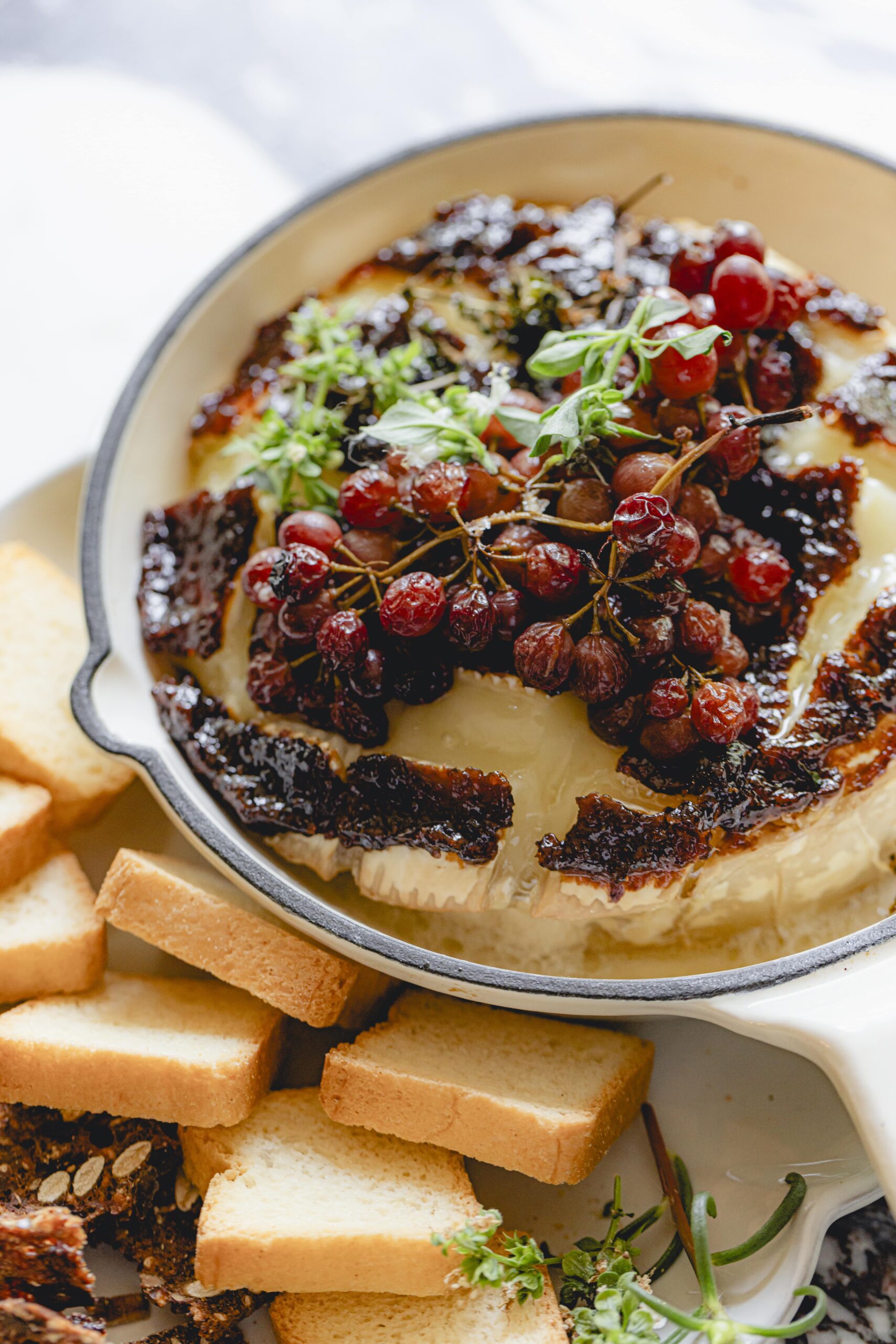 Baked brie with grapes and fig jam in a mini skillet.