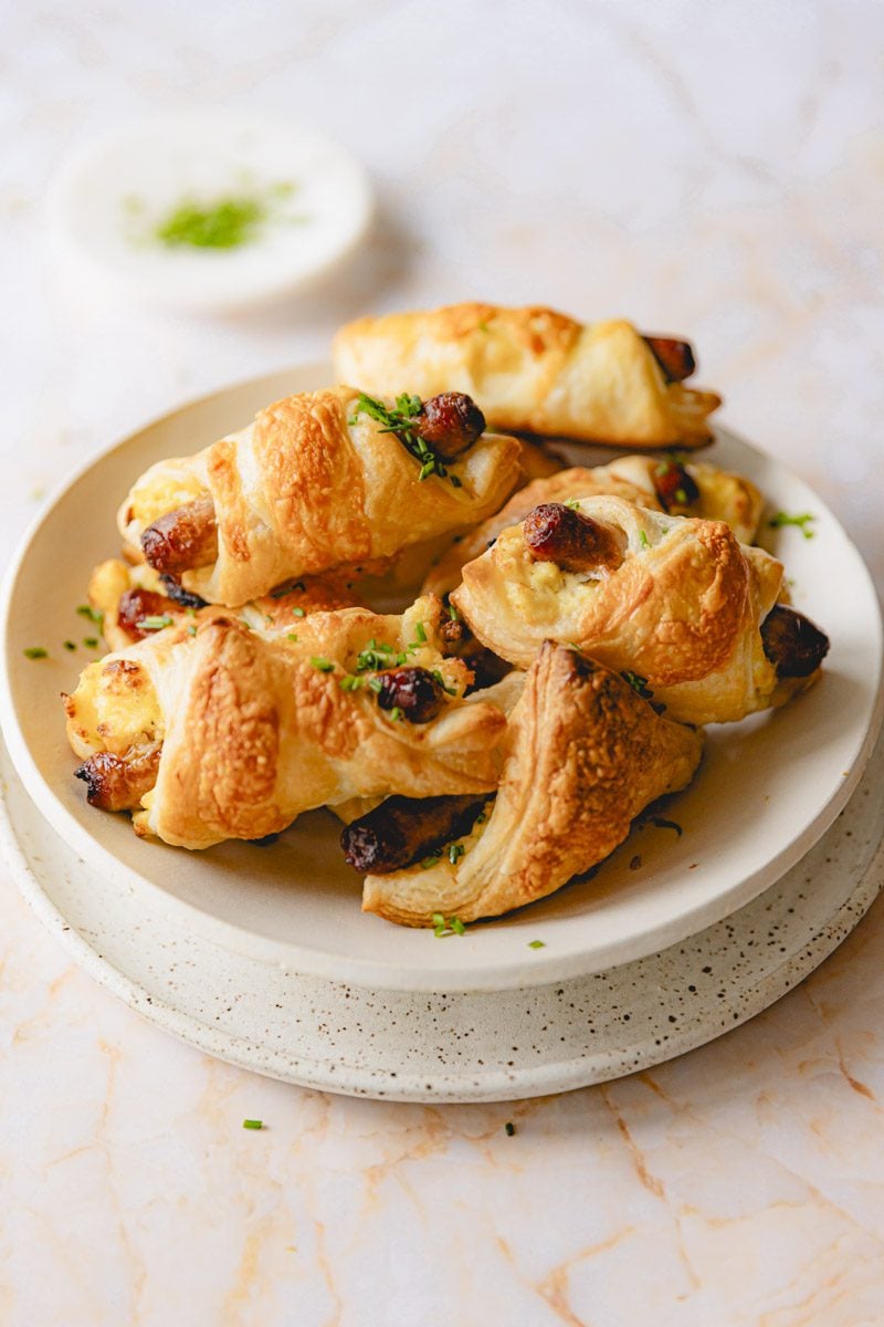 Plate of puff pastry wrapped breakfast sandwiches. 