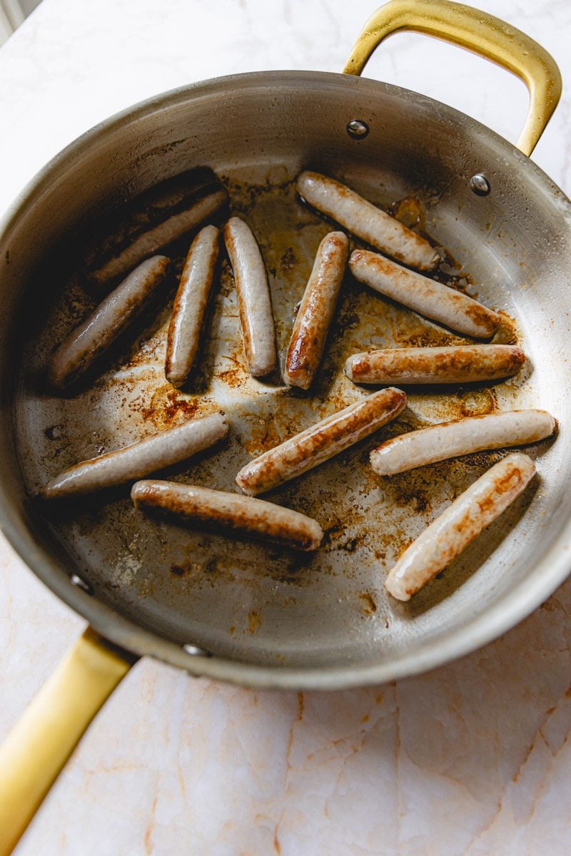Sausage cooking in a skillet.