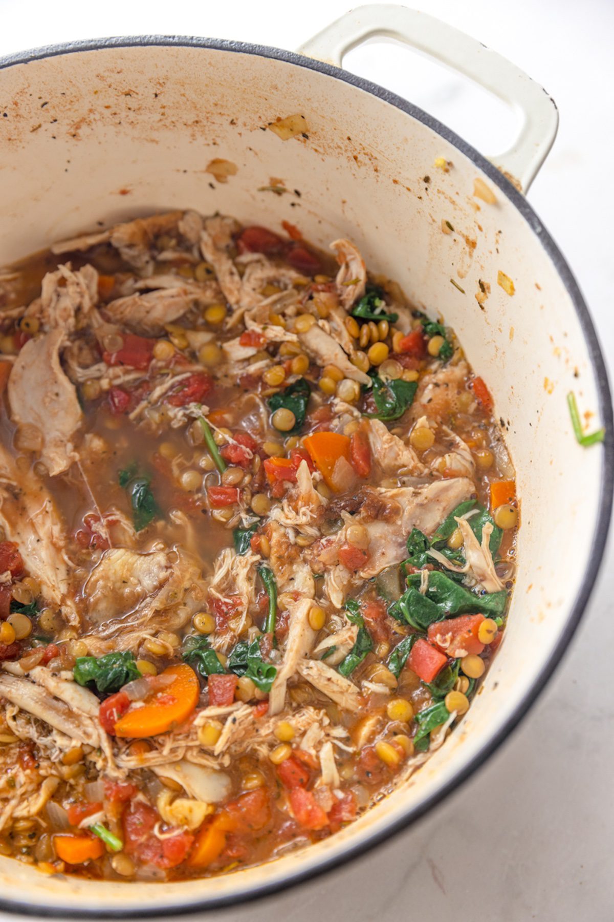 Parsley garnished turkey lentil soup.