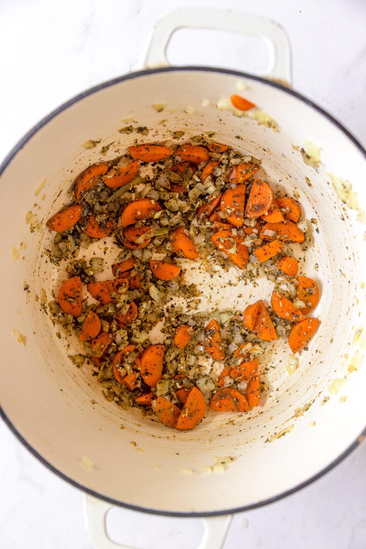 Spices stirred into vegetables in dutch oven.
