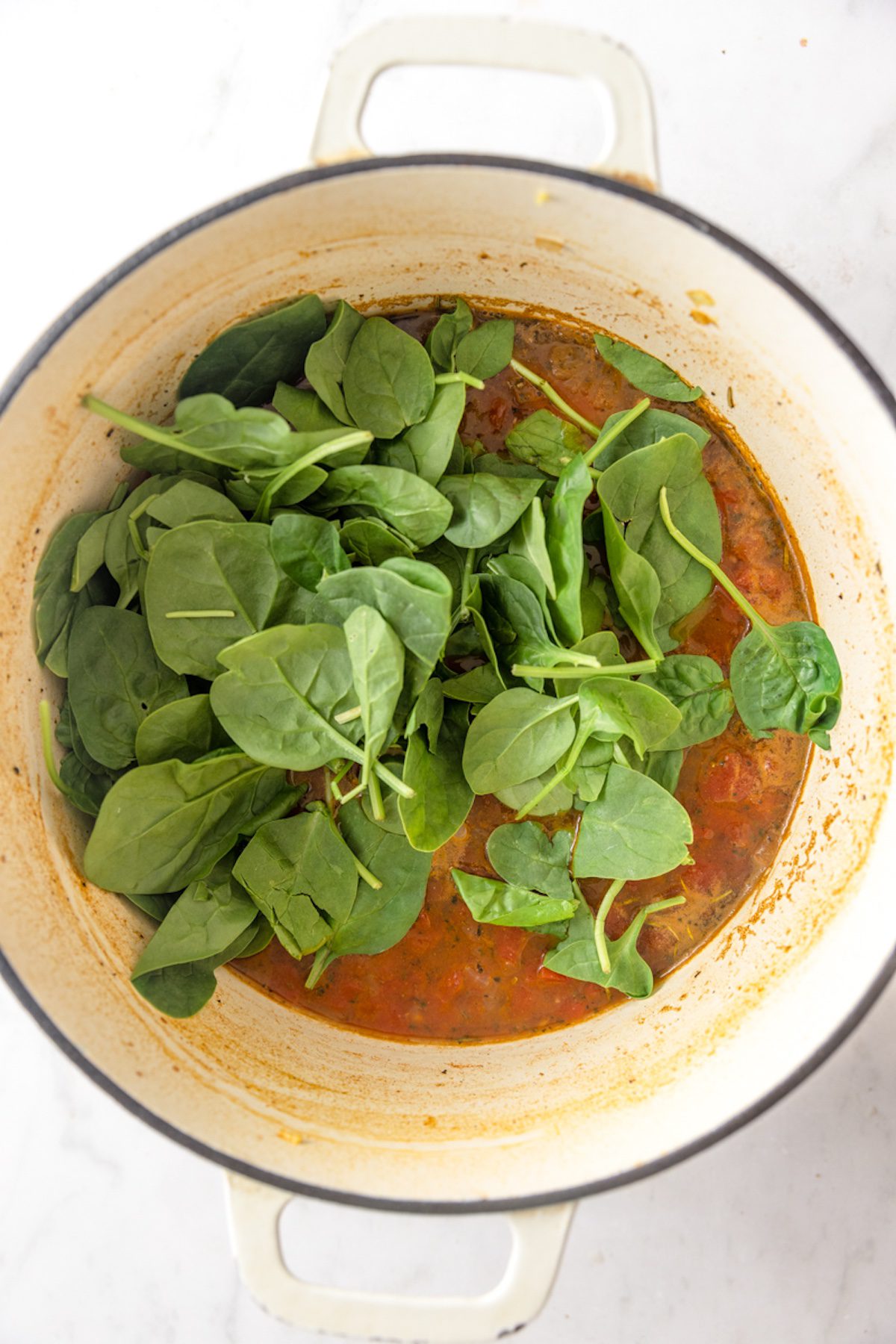 Spinach added to turkey lentil soup.