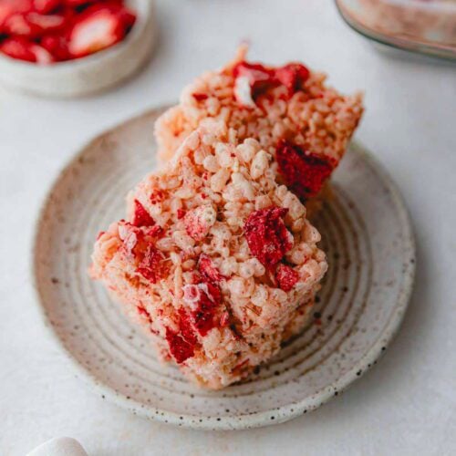 Pink Rice Krispie treats on a white plate.