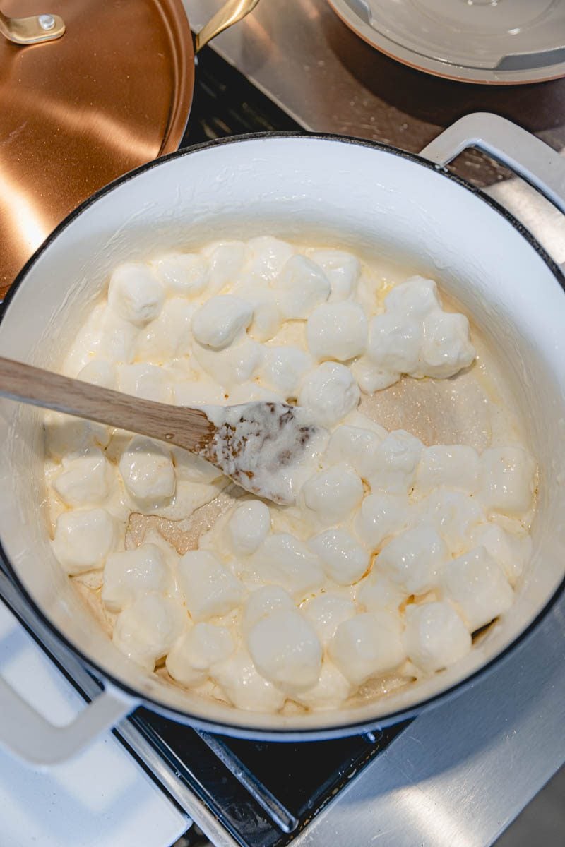 Melting marshmallows and butter together in a saucepan.